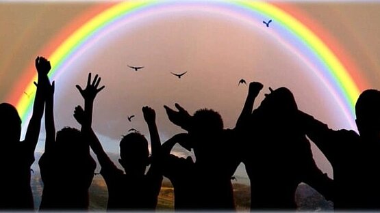 schwarze Silhouetten unter einem Regenbogen