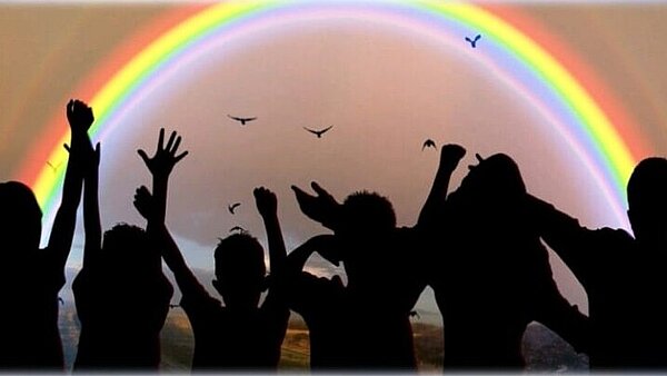 Unter dem Regenbogen schwarze Silhouetten unter einem Regenbogen