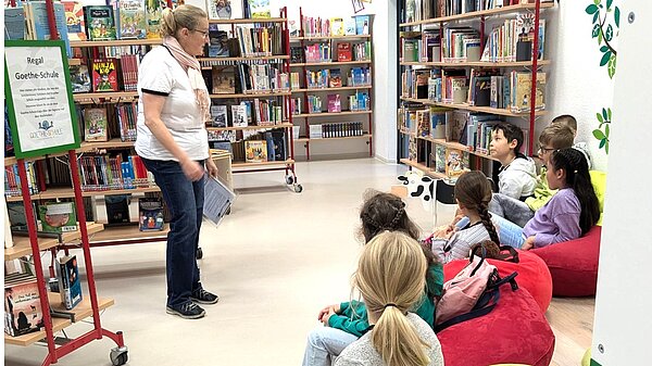 Kommunionkinder sitzen in der Bibliothek 