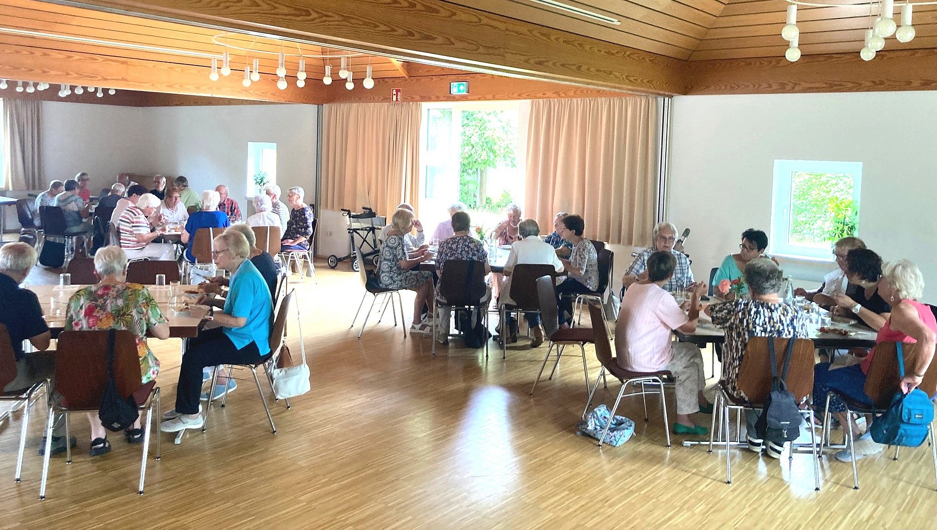 Blick in den Gemeindesaal bei Mittagstisch im Ausgust