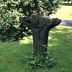 In einen Baumstamm geschnitzte Jesusfigur am Kreuz 