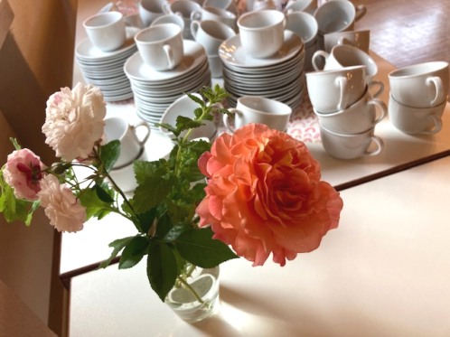 bereitgestellte Kaffeetassen mit Rosenstrauß